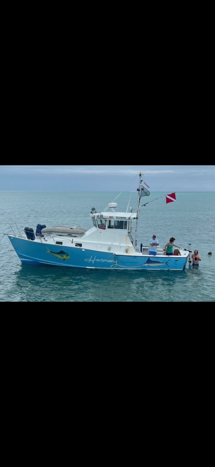35-foot Striker with blue hull, painted mahi and marlin, dive flag flying